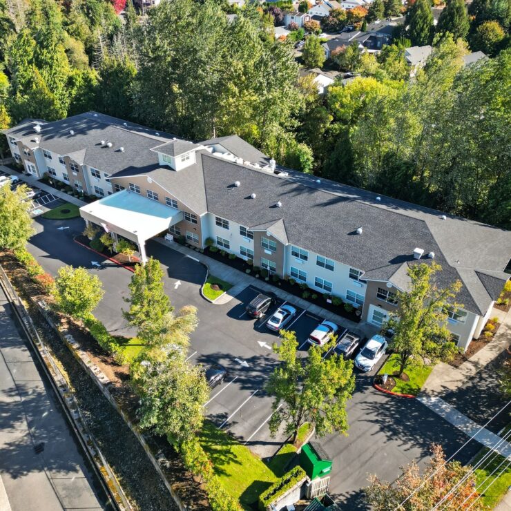 Retirement home nestled among lush trees with spacious parking and peaceful surroundings.