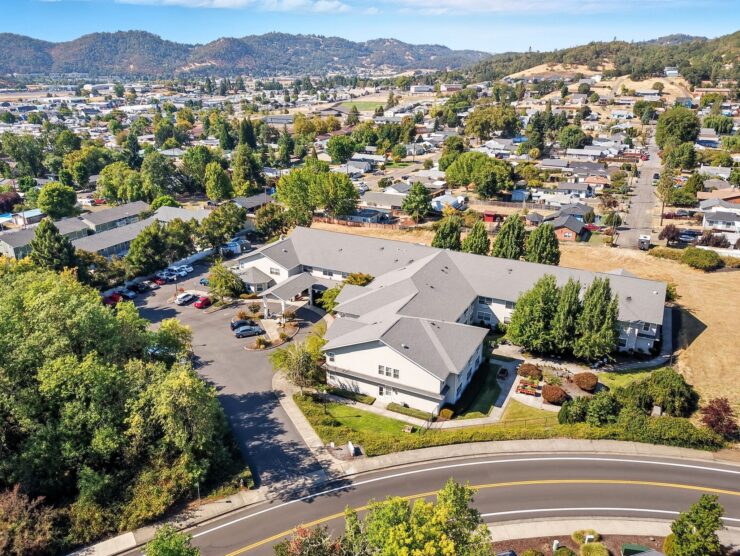 Retirement community surrounded by lush trees and scenic hills for peaceful living.