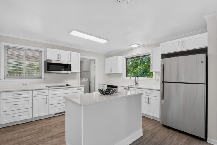 Bright kitchen with ample counter space, modern appliances, and a window view of greenery.