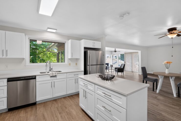 Bright kitchen with modern appliances opens to a comfortable seating area for relaxed socializing.
