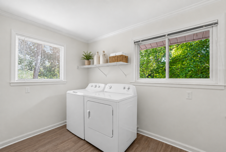 Bright, clean laundry room with modern appliances and natural views fostering a welcoming community feel.