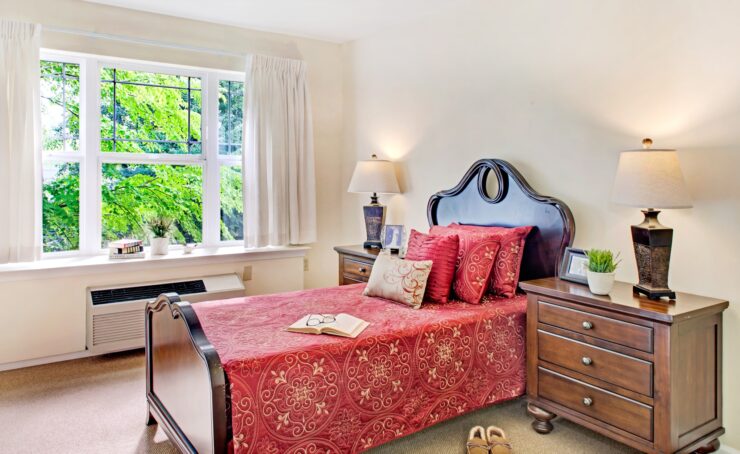 Sunlit bedroom with warm wood furniture, vibrant bedding, and peaceful garden views.