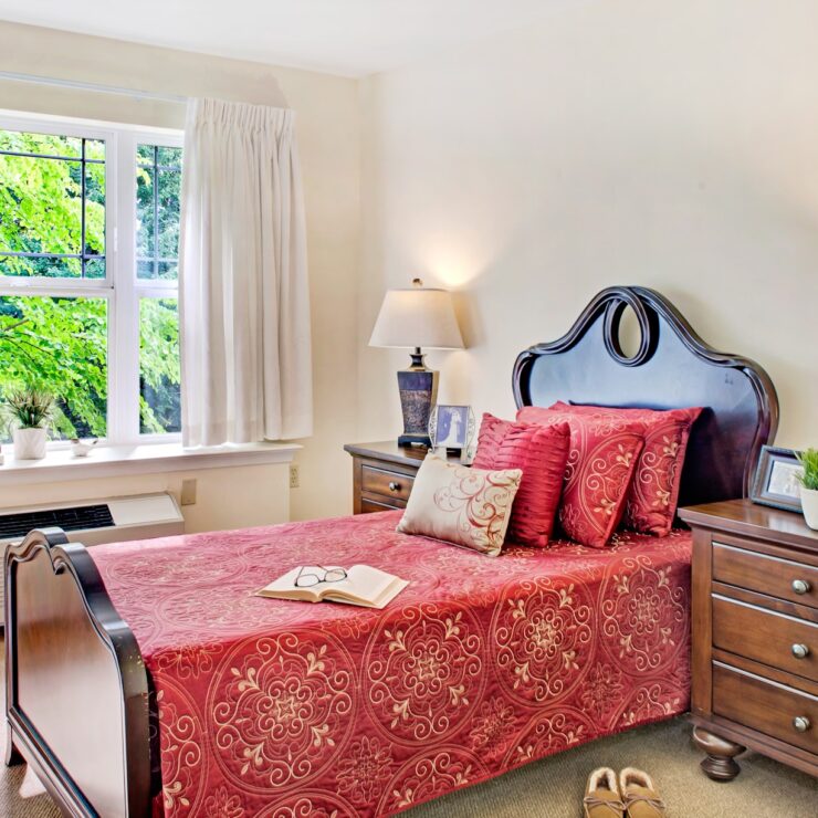 Sunlit bedroom with warm wood furniture, vibrant bedding, and peaceful garden views.