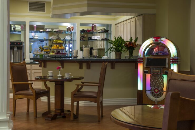 Dining area with a vintage jukebox, fresh fruit display, and inviting seating for social gatherings.