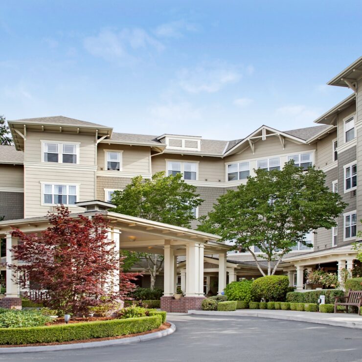 Welcoming retirement community building surrounded by trees and well-maintained gardens.