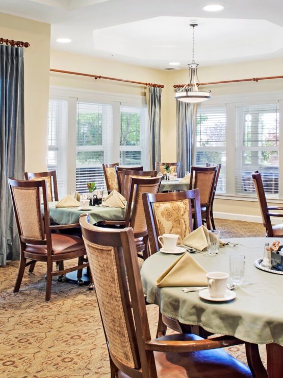 Sunlit dining room with neatly set tables and inviting seating for communal meals.