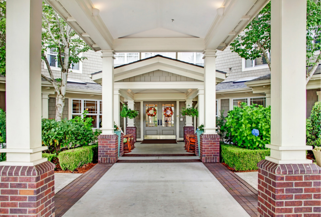 Welcoming entrance with rocking chairs and vibrant greenery, inviting a sense of community and comfort.