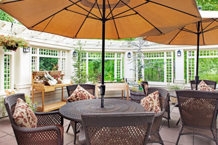 Patio seating area with umbrellas, comfortable chairs, and lush greenery for relaxation and community.