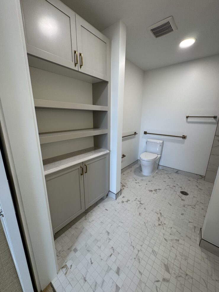 Bright bathroom with accessible features and ample storage for resident comfort and convenience.