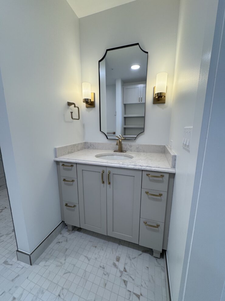 Well-lit bathroom vanity with elegant fixtures and ample storage reflecting a welcoming community space.