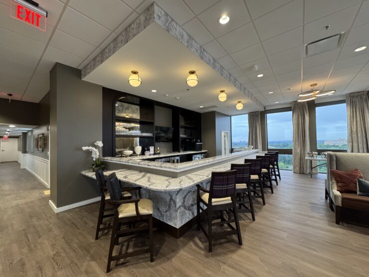 Elegant lounge area with marble counters, ample seating, and large windows overlooking greenery.