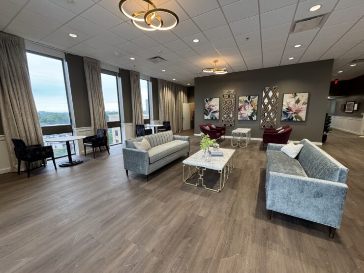 Spacious lounge with large windows, comfortable seating, and warm lighting for community gatherings.