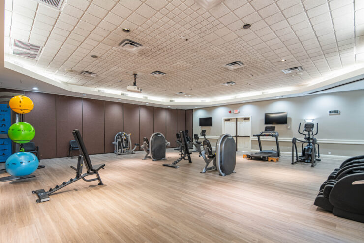 Well-lit gym with cardio and strength equipment encouraging active community living.