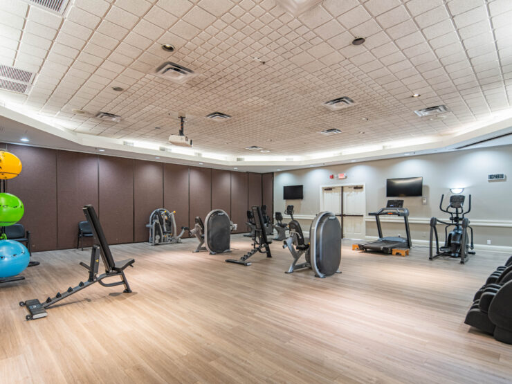 Well-lit gym with cardio and strength equipment encouraging active community living.