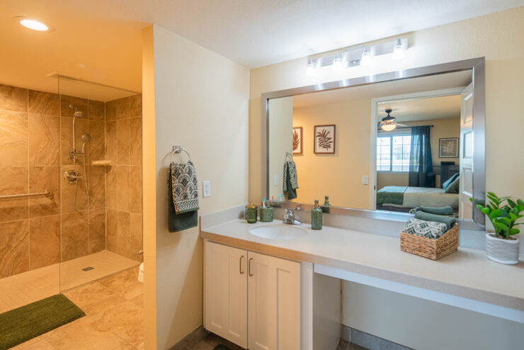 Bright bathroom with walk-in shower, large mirror, and calming neutral decor.