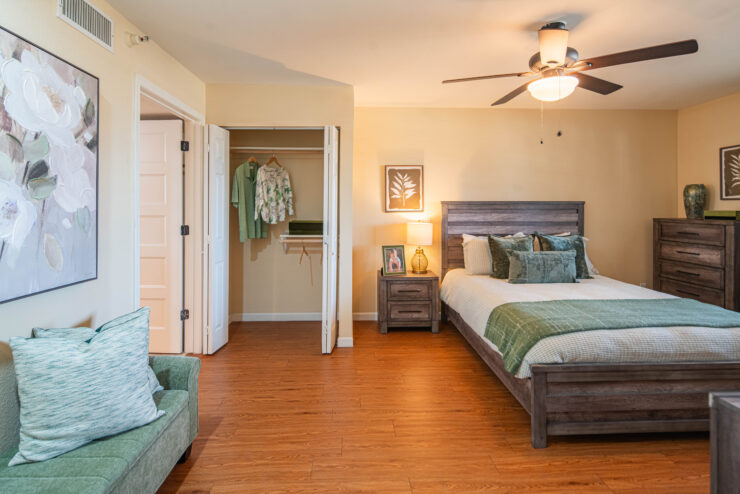 Spacious bedroom with warm lighting, comfortable bed, seating area, and thoughtful decor.