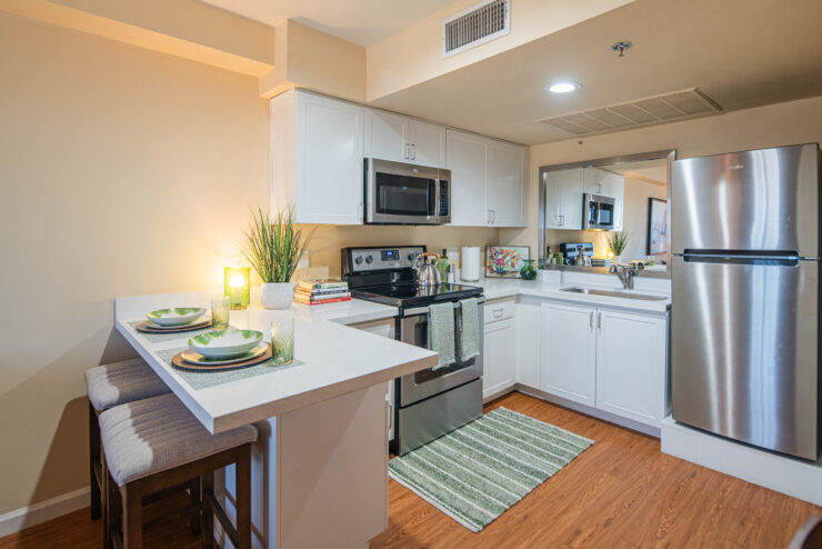 Bright, modern kitchen with seating, stainless appliances, and welcoming dining space for residents.