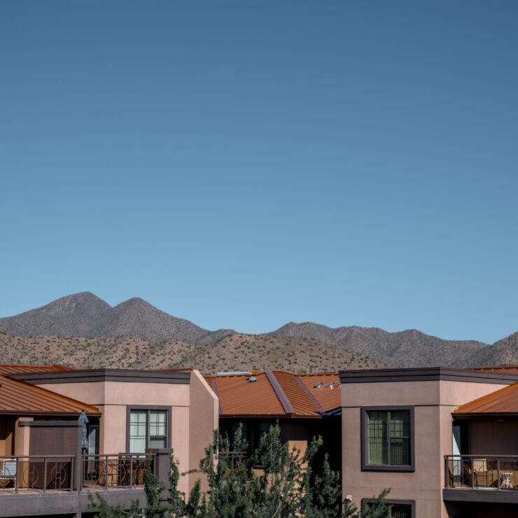 Modern senior living community with private balconies and scenic mountain views in the background