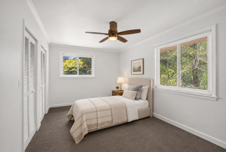 Bright, peaceful bedroom with natural light, soft bedding, and a calming view of greenery.