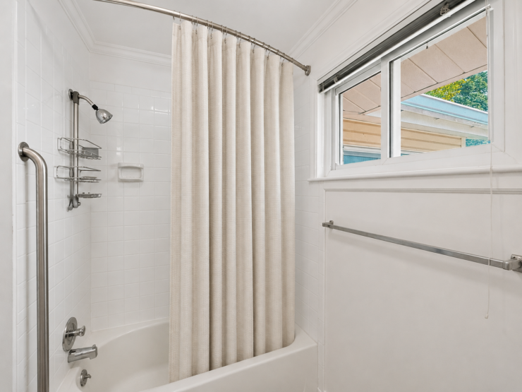 Bright, accessible bathroom with safety handrails and natural light for comfortable daily care.