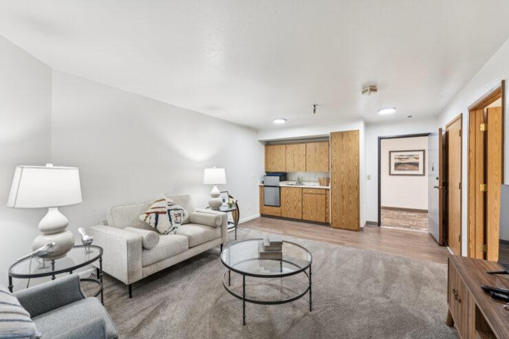 Bright living area with comfortable seating, soft lighting, and a compact kitchenette offering a welcoming space.