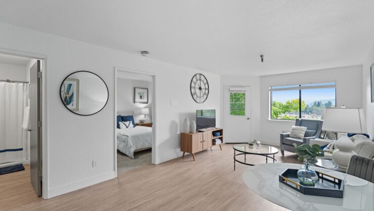 Bright living space with modern furnishings, natural light, and a view of lush greenery.