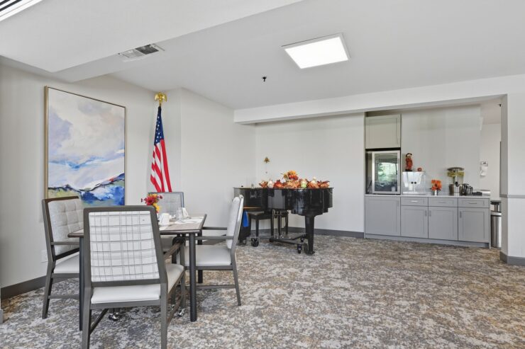 Bright dining area with comfortable seating, piano, and friendly communal atmosphere
