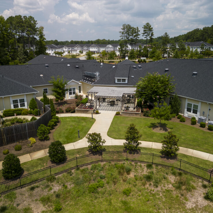 Well-maintained retirement community with lush landscaping, outdoor seating, and peaceful surroundings.