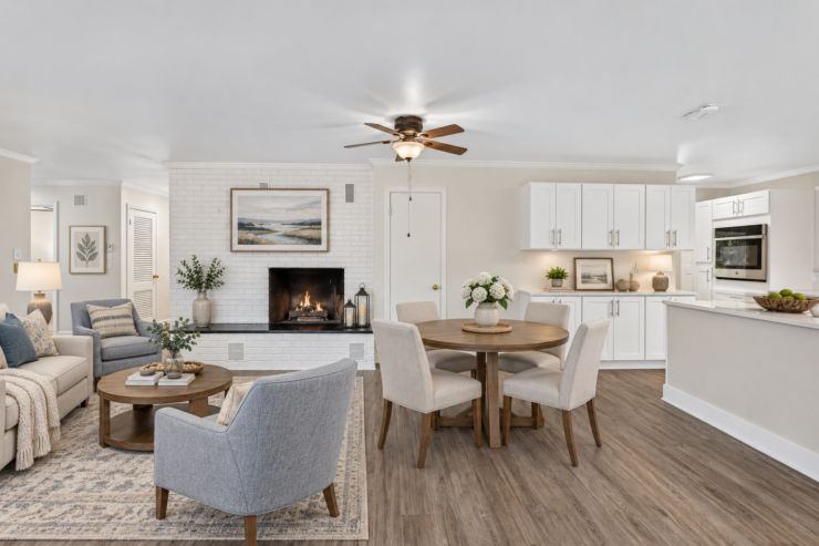 Bright, inviting living and dining area with a fireplace, comfortable seating, and warm decor.