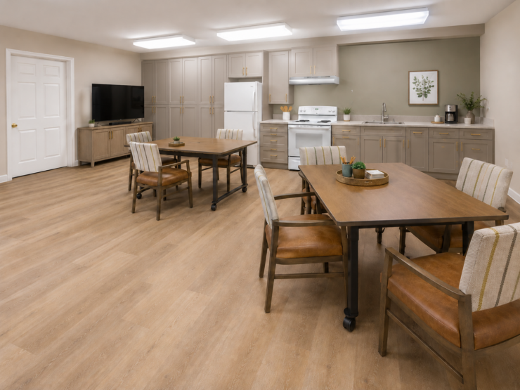 Bright and inviting activity room with seating, kitchen area, and welcoming atmosphere for residents.
