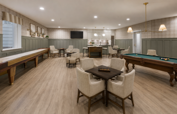 Spacious game room featuring comfortable seating, a pool table, and a shuffleboard for active relaxation.