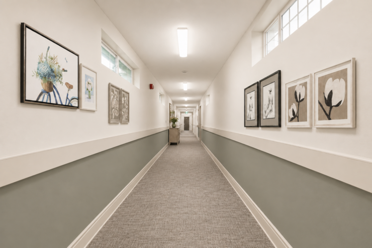 Well-lit hallway with soft artwork and calming colors, inviting a warm and welcoming community.