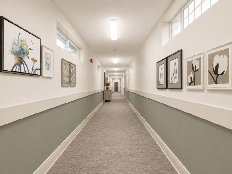 Well-lit hallway with soft colors and artwork, creating a welcoming and peaceful environment.
