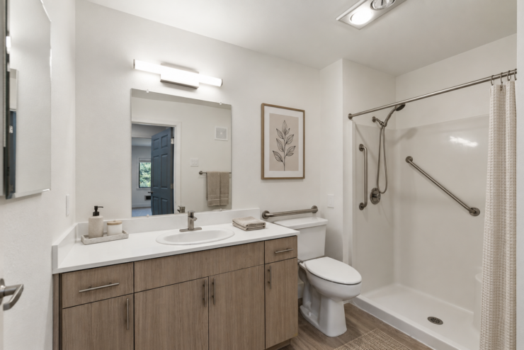 Bright, accessible bathroom with safety rails and modern amenities promoting independence and comfort.