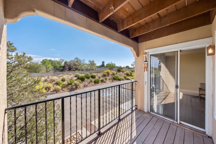 Sunlit balcony overlooking landscaped gardens and serene natural surroundings.