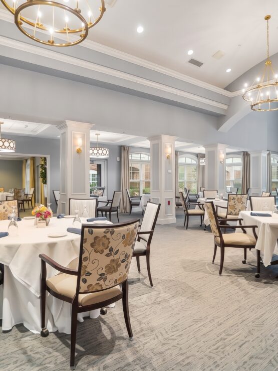 Elegant dining room with floral chairs, white tablecloths, and warm lighting for community gatherings.