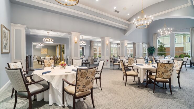 Elegant dining room with floral chairs, white tablecloths, and warm lighting for community gatherings.