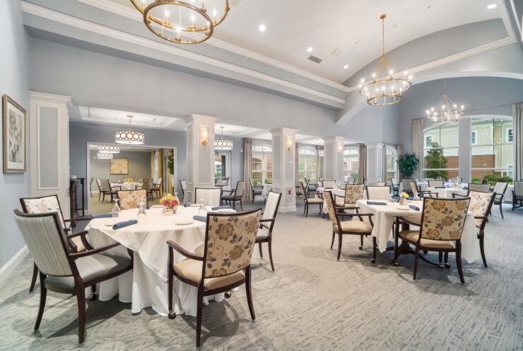 Elegant dining room with floral chairs, white tablecloths, and warm lighting for community gatherings.