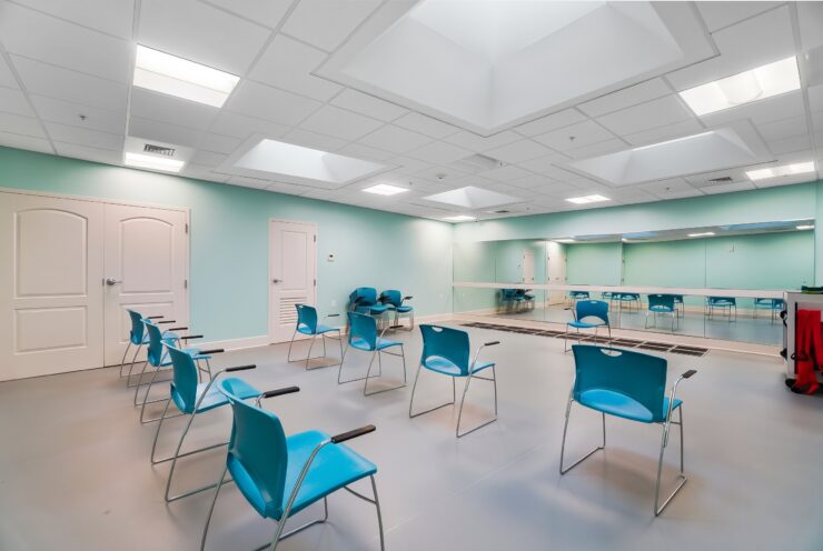 Bright and spacious fitness room with ample seating, promoting wellness and social connection.