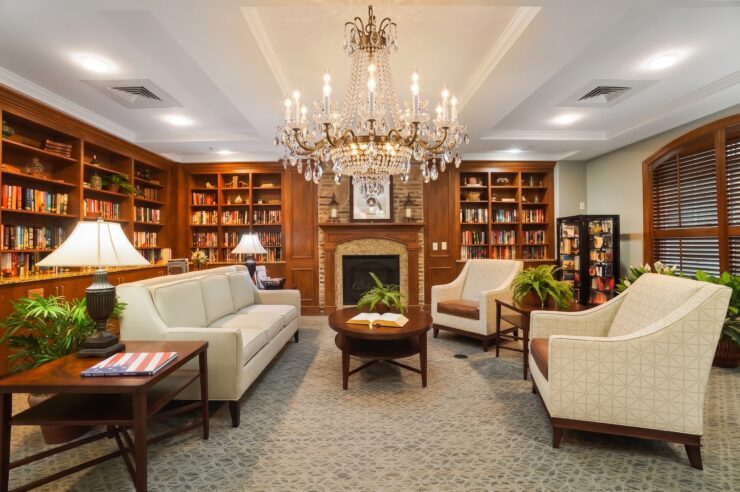 Elegant library with comfortable seating, warm lighting, and inviting fireplace for relaxing moments.