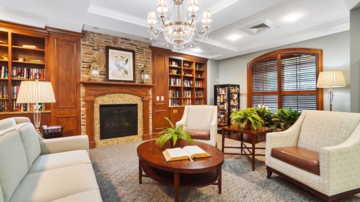 Inviting library space with plush seating, warm lighting, and a fireplace for relaxing gatherings.