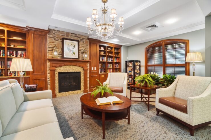 Inviting library space with plush seating, warm lighting, and a fireplace for relaxing gatherings.