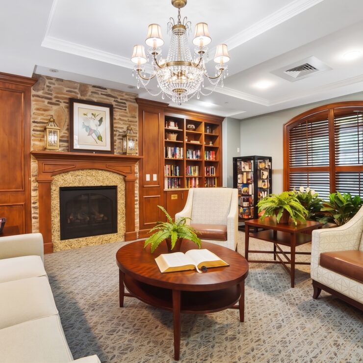 Inviting library space with plush seating, warm lighting, and a fireplace for relaxing gatherings.