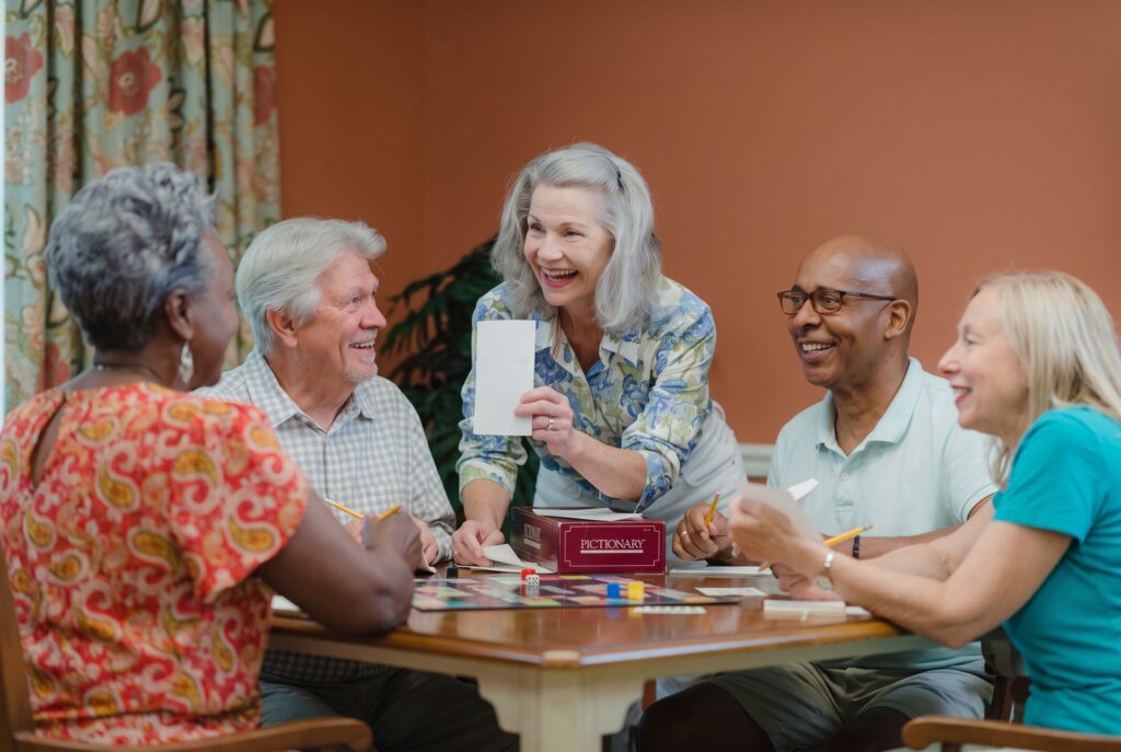 Seniors enjoying a lively board game in a warm, inviting community room with friendly smiles.