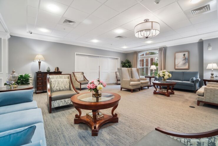 Spacious lounge with comfortable seating, soft lighting, and floral accents fostering a welcoming community.