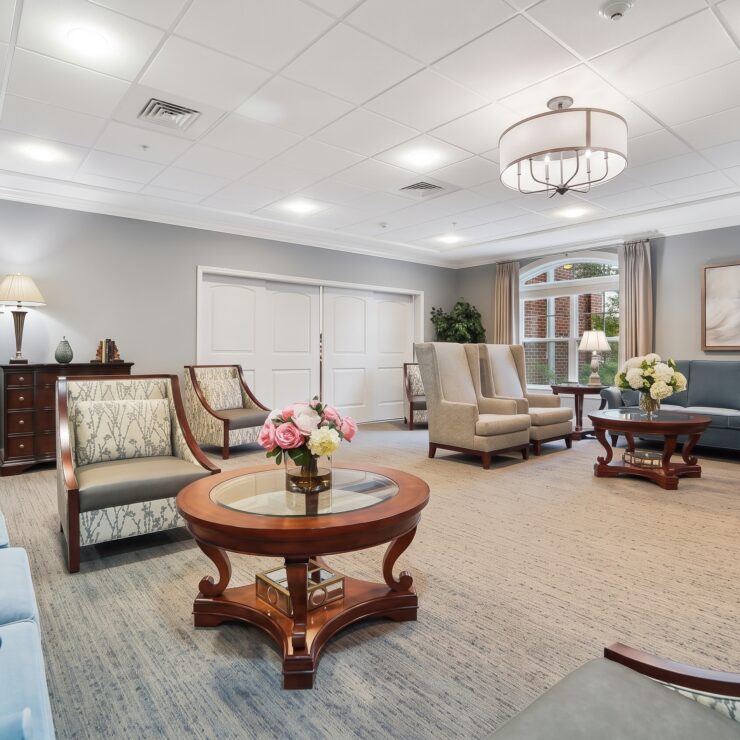 Spacious lounge with comfortable seating, soft lighting, and floral accents fostering a welcoming community.