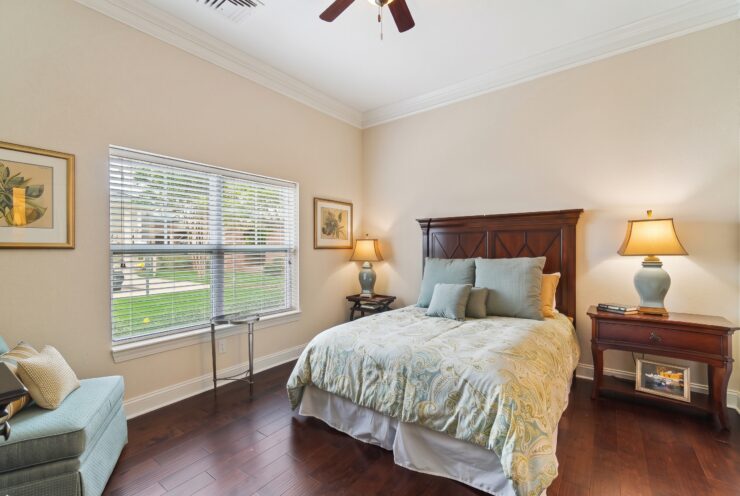 Bright and inviting bedroom with classic furnishings, soft lighting, and scenic window views.