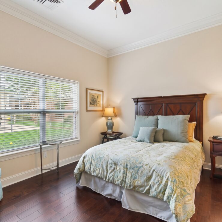 Bright and inviting bedroom with classic furnishings, soft lighting, and scenic window views.