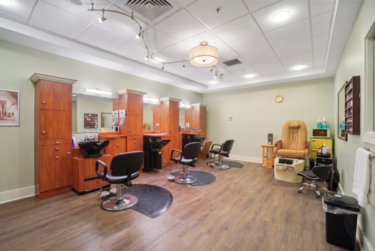 Well-lit salon with comfortable seating, wood accents, and welcoming atmosphere for residents.