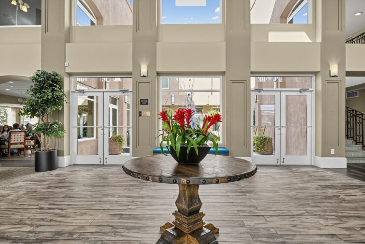 Bright, welcoming foyer with natural light, vibrant flowers, and seating for community gatherings.